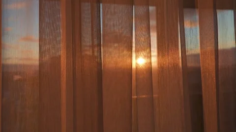 Golden hour sun setting behind sheer curtains Stock Footage 326098895
