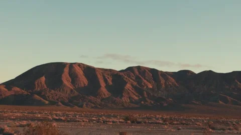 Golden hour sun setting on a distant desert mountain range 스톡 동영상 346008129