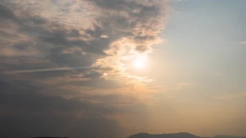 Golden Hour Sunlight Piercing Through Clouds Over Distant Mountain Silhouette Stock Footage 341996845
