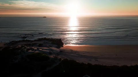 Golden hour sunlight reflecting on calm Atlantic Ocean waves aerial seascape Stock Footage 330879697