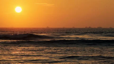 Golden Hour Sunset Over Dark Ocean Waves with Distant Ship Silhouettes 스톡 동영상 344163225