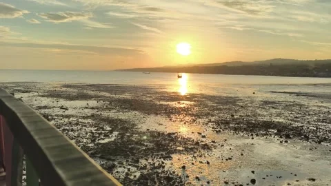 Golden Hour Sunset Over Low Tide Coastal Beach with Distant Boat Video stock 340464922