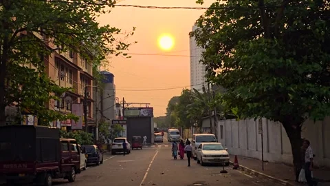 Golden Hour Sunset Over Side Road with Vehicles and People in Motion Stock-Footage 304170939