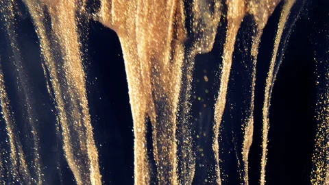 Golden ink particles flows in water as colorful chaos on the black background Stock Footage 124366341