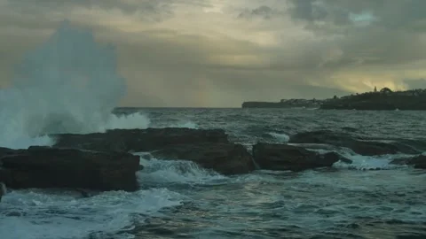 Golden light and rainbow with wave hitting rocks 4K Stock Footage 276099973