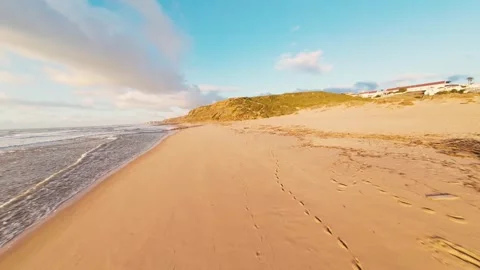 Golden light dances on wet sand and waves Stock Footage 340913546