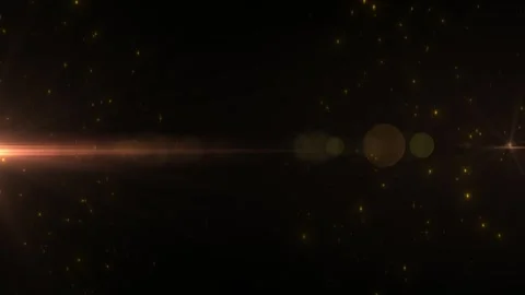 Golden light flare with floating particles on a dark background, creating a c 库存影片 331513789