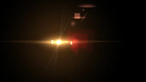 Golden light flare with particles moving from left to right on a dark background Stock Footage 275469412