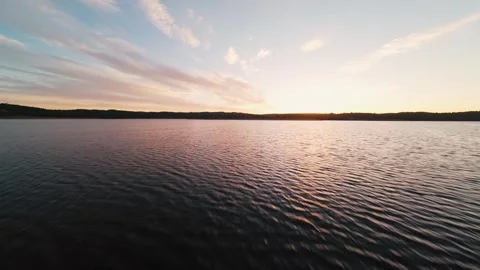 Golden light glows over calm water at Pego do Altar Reservoir, Alcacer do Sal Stock Footage 342160545