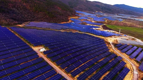 Golden light over solar panel field near forest, Bulgaria Stock Footage 346386535