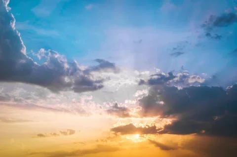 Golden light shining through the clouds in a colorful evening at sunset and.. Stock Photos
