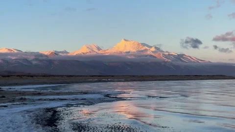 Golden Light on Snow Mountains Reflected in Plateau Lake at Sunrise or Sunset, Stock Footage 338211367