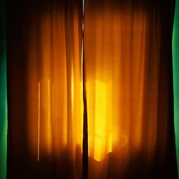 Golden light streams through sheer curtains Stock Photos