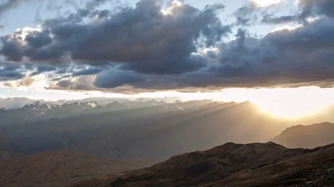 Golden light as the sun sets behind mountains Stock Footage 75887601