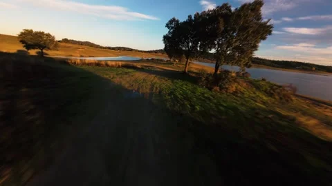 Golden light sweeps over grassy fields and quiet waters Video stock 342183965