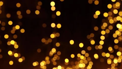 Golden lights flash against a black background, bokeh Stock Footage 164189257