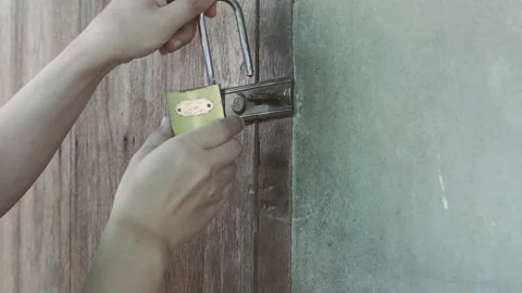 Golden lock, Young man locked the door with a padlock before leaving the hous Stock Footage 152088613