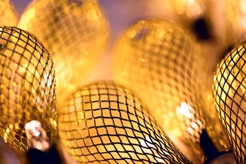 Golden macro background - lighted retro garland lights. Festive mood close-up Stock Photos