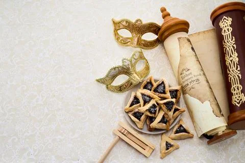 Golden mask, scroll, gragger, and hamantaschen on decorative background Stock Photos