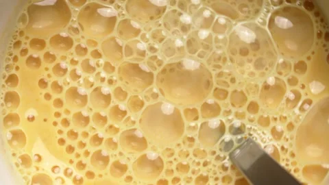 Golden milk foam bubbles moving in circular motion Stock Footage 336076397