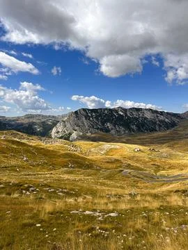 Golden mountain meadows under dramatic clouds in a serene landscape Stock Photos