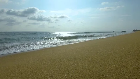 Golden ocean beach with waves rolling in under a cloudy sky sunny day Video stock 307416334