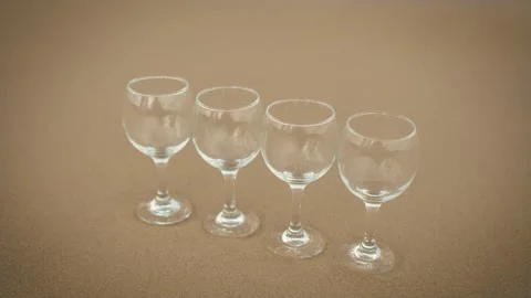 Golden ocean sand with four empty glasses near waves on beach Stock Footage 253257428