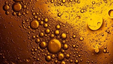 Golden oil bubbles creating abstract liquid texture 库存照片