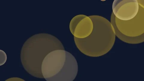 Golden orbs float softly against a deep navy background 動画素材 342153437