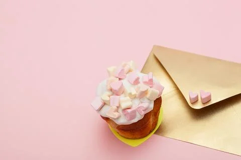 Golden paper envelope with two hearts from marshmallow and valentine cupcake Stock Photos