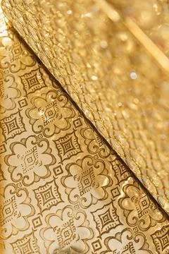 Golden patterns are arranged on a flat surface with detailed designs. Light r Stock Photos