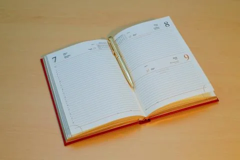 A golden pen is embedded in a notebook Stock Photos