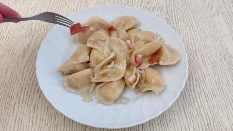 Golden Pierogi with Crispy Bacon Bits on White Plate- Comfort Food Stock-Footage 320098210