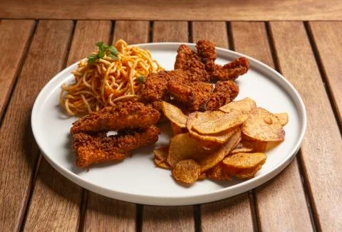 Golden plate. Tenders, spagetti and potato chips. Stock Photos