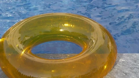 Golden pool float drifting across blue water creates clean tropical background Stock Footage 345653795
