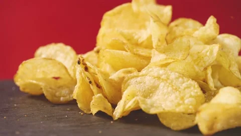 Golden potato chips falling on red background. food background. Salted potatoes  Stock Footage 149660267
