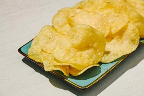 Golden potato chips on a turquoise rectangular plate Stock Photos