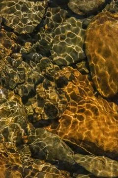The golden reflection of the sunlight on the waves of the river Pomeca stream Foto stock