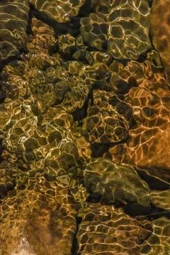 The golden reflection of the sunlight on the waves of the river Pomeca stream Foto stock