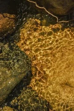 The golden reflection of the sunlight on the waves of the river Pomeca stream Foto stock