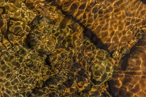 The golden reflection of the sunlight on the waves of the river Pomeca stream Foto stock