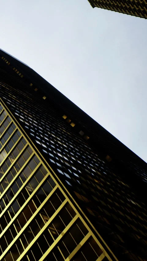 Golden reflections dance on modern architecture under an expansive sky Video stock 334246852