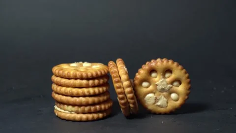 Golden, ridged crackers stack neatly on dark surface Stock Footage 340906319