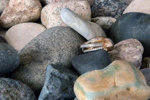 Golden ring lying on a pebble Stock Photos