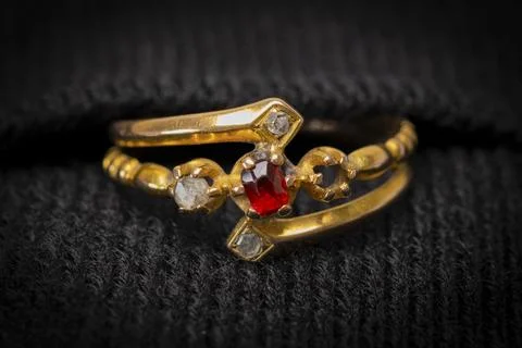 Golden ring with ruby and diamonds gleams softly Stock Photos