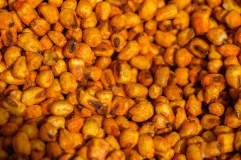 Golden roasted corn kernels create a delicious snack enjoyed at bustling ma.. Stock Photos