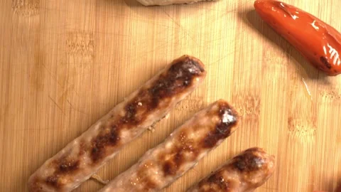 Golden Roasted Pork Sausage with Rustic Garnishes on Wooden Board Stock Footage 314799644