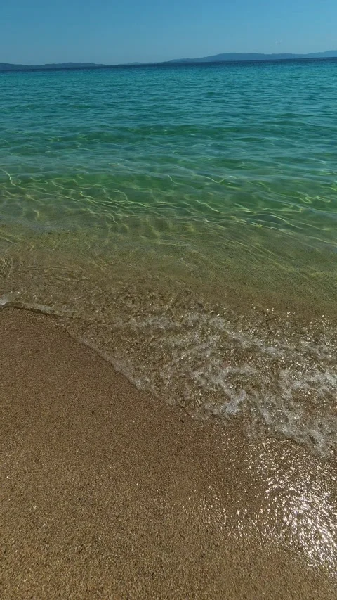 Golden sand meets turquoise waves. Trani Ammouda, Greece. Vertical Stock Footage 339630460