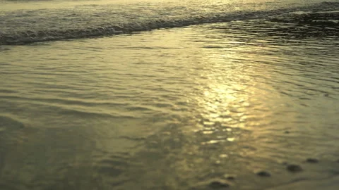 Golden sand with rolling waves at sunset Stock Footage 112952158