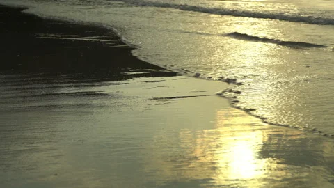 Golden sand with rolling waves at sunset Stock Footage 112952426